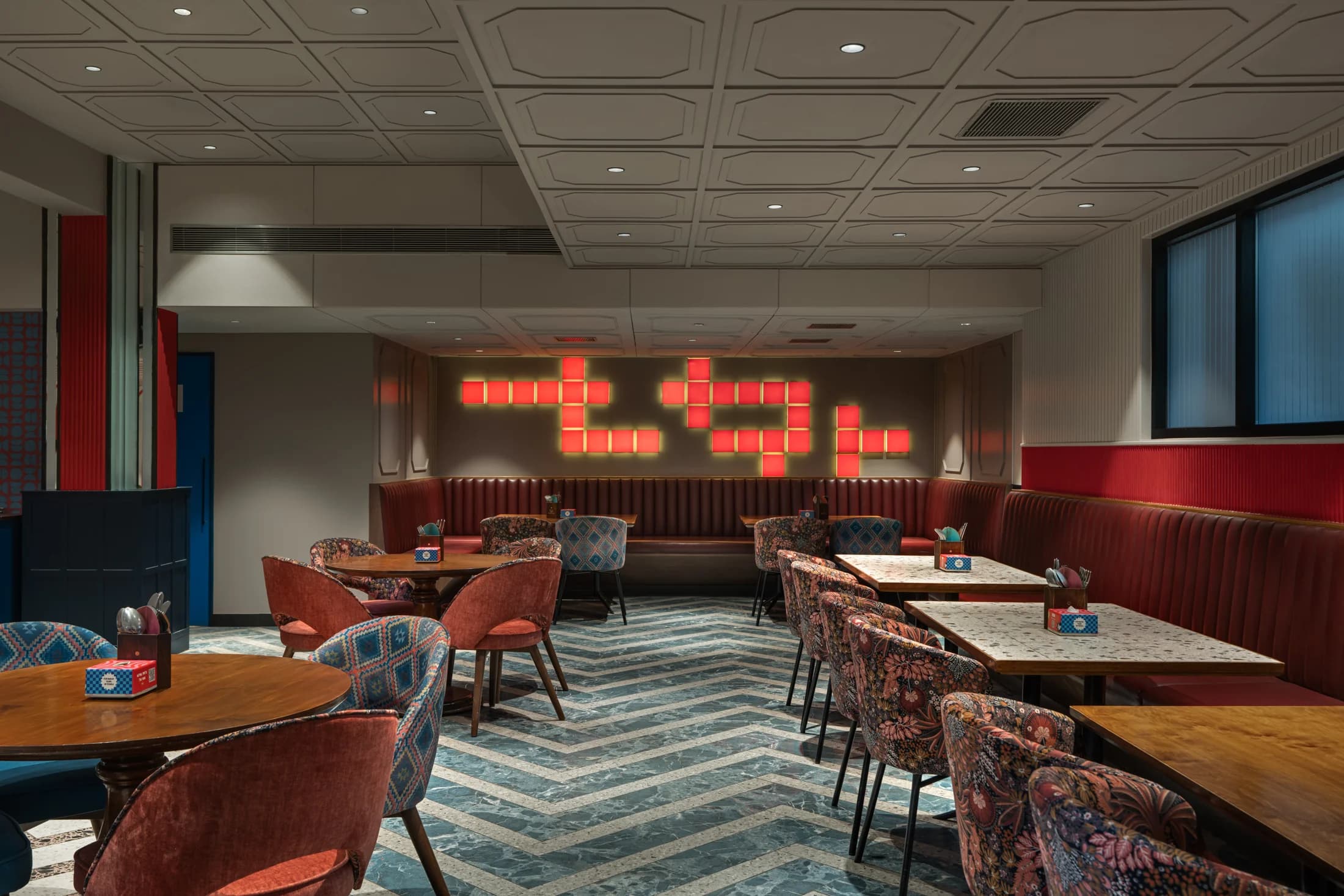 Red banquettes and dining tables in Heyou Dining upstairs